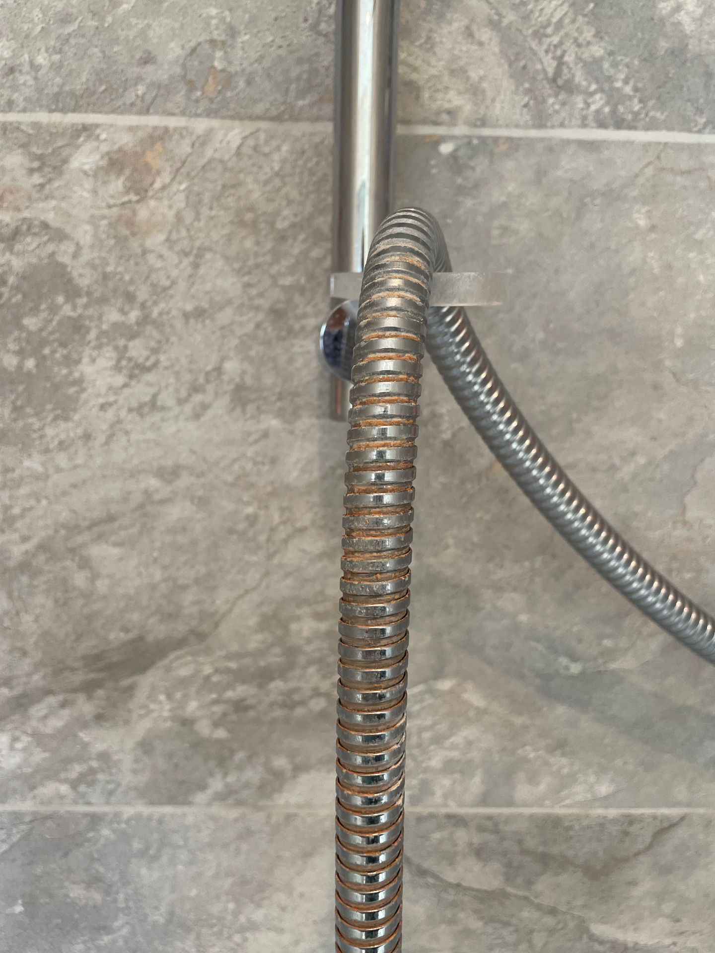 Shower hose before clean — rust & limescale build up